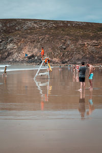 People standing in water against sky