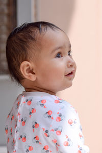 Close-up of cute baby girl looking away