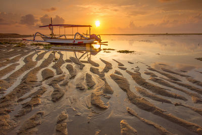 Scenic view of sandy beach at sunset