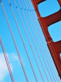 Low angle view of suspension bridge cables against sky