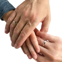 Cropped image of parents holding child hand against white background