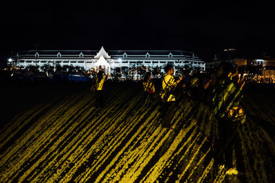 Group of people working on bridge at night