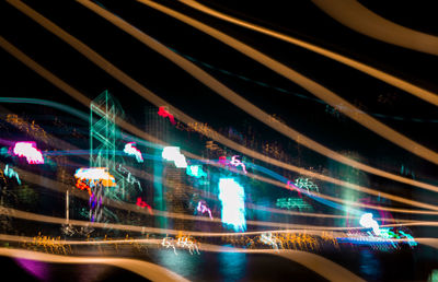 Illuminated light trails on road in city at night