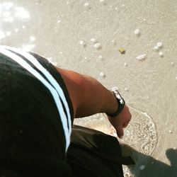 Low section of man standing on beach