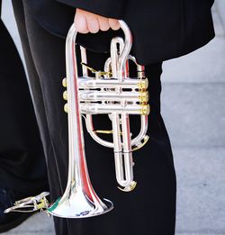 Midsection of man holding trumpet