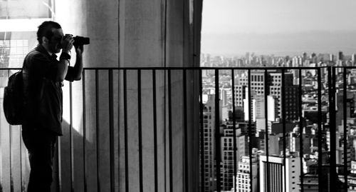 Man looking at cityscape through binoculars