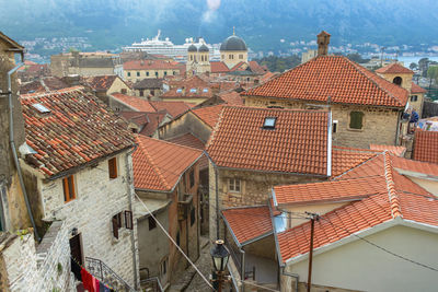 Stone houses, red tiled roofs, and the font of the temple. the old town in boko-kotor bay