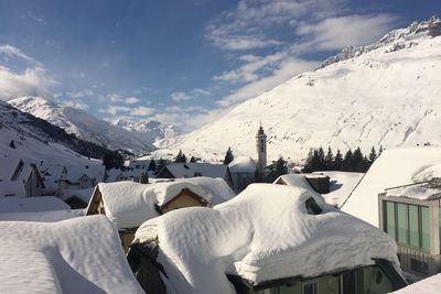 Panoramic view of snow covered mountains against sky