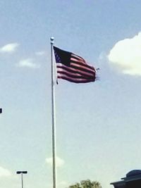 Low angle view of american flag against blue sky