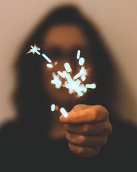 Close-up of hand holding sparkler at night