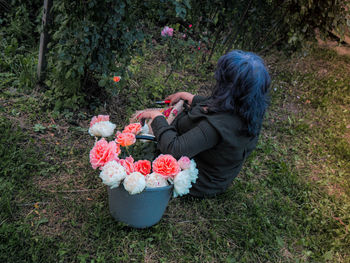 Senior woman with flower basket in the garden