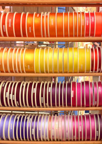 Full frame shot of multi colored ribbons arranged on shelves in store