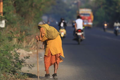 Rear view of man walking on road