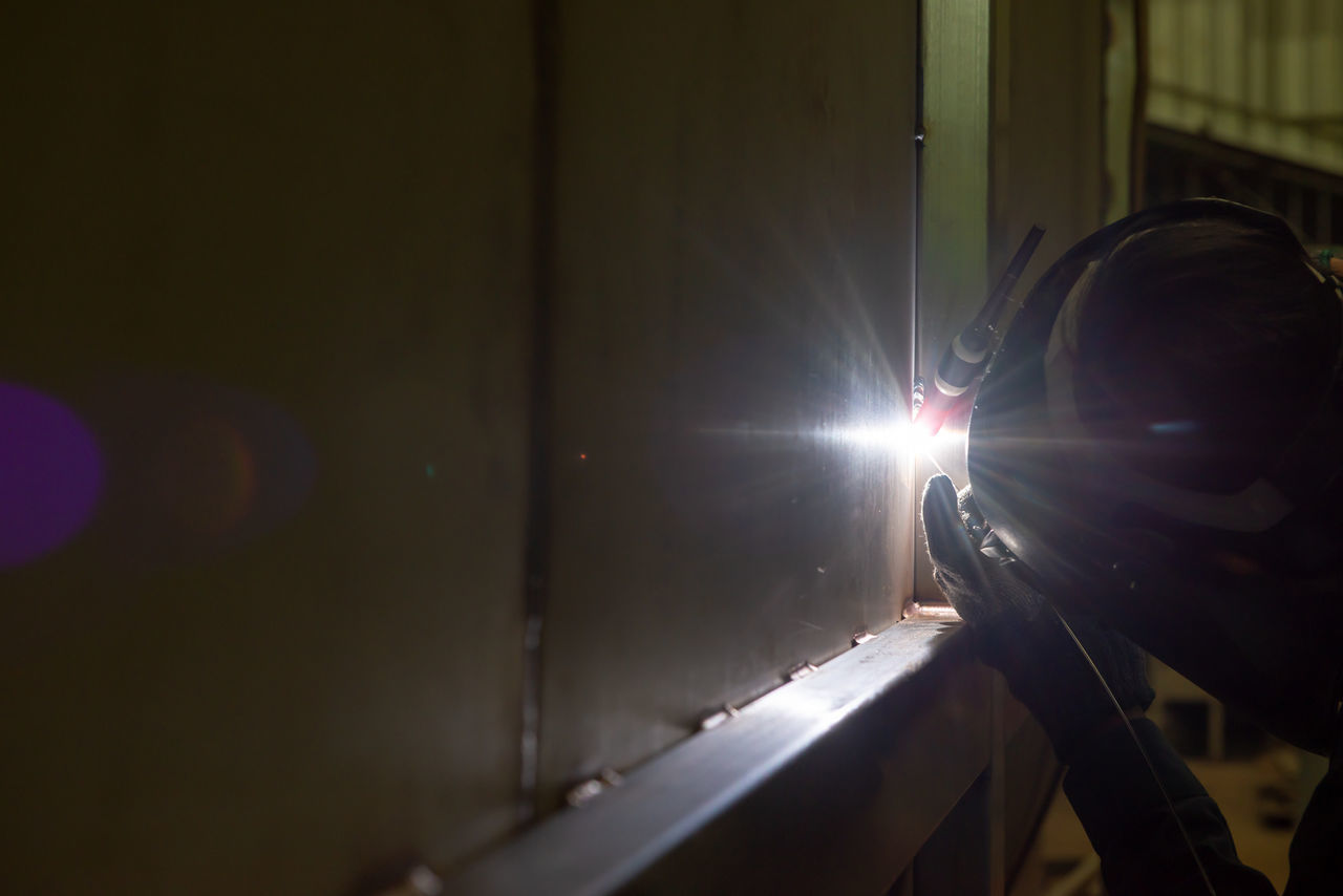 MAN SEEN THROUGH METAL WINDOW