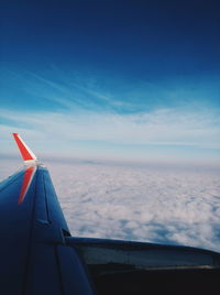 Close-up of airplane wing against cloudy sky