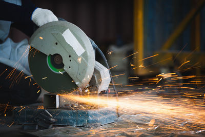 Manual worker using grinder at factory