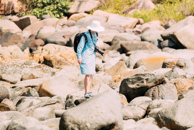 Rear view of woman walking on rocks