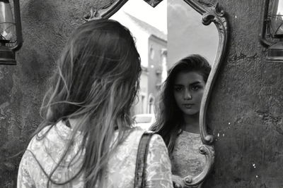 Reflection of thoughtful woman on mirror