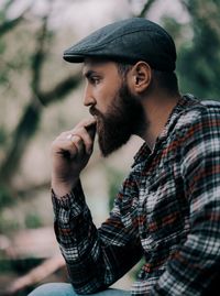 Side view of bearded young man looking away