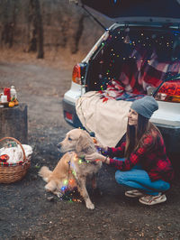 People with dog sitting in park during winter