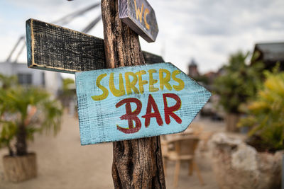 Close-up of text on wood against trees