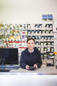 Portrait of confident sales clerk in electronics store