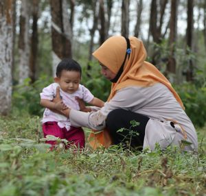 Rear view of mother and baby on land