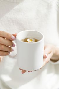 Midsection of woman holding coffee cup