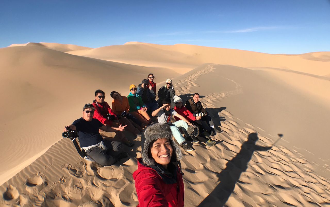 real people, desert, group of people, sand dune, sunlight, land, lifestyles, leisure activity, nature, sand, climate, people, scenics - nature, sky, adult, environment, landscape, women, casual clothing, men, arid climate, outdoors