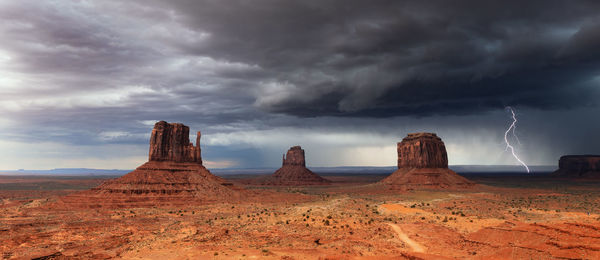 Rock formations on field against sky