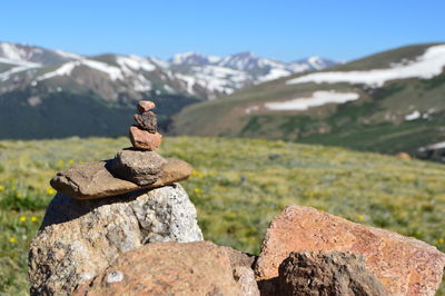 Stack of rocks on field against mountain