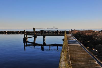 Bridge over river against clear blue sky