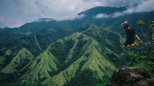 Man jumping against mountains