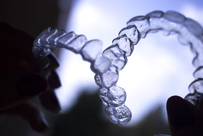 Close-up of icicles against blue metal