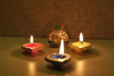 Close-up of illuminated candles on table