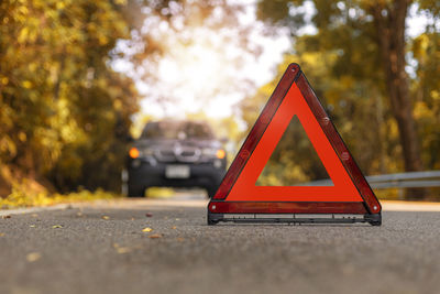 Close-up of sign on road against trees