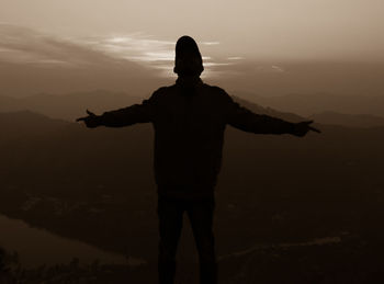 Rear view of silhouette man standing against sky