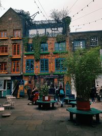 People by buildings in city against sky
