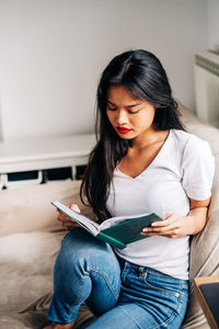 Young woman using mobile phone at home