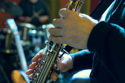 Midsection of man playing saxophone during performance