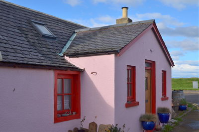 Exterior of house by building against sky