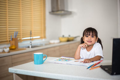 Portrait of cute girl studying at home