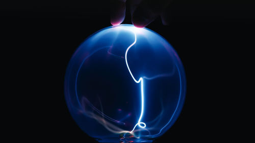 Touching plasma ball on black background