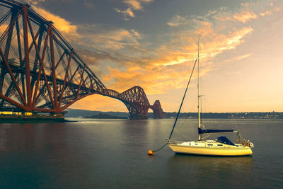 Sailboat on bridge over river against sky