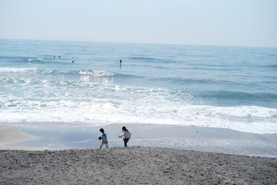 People at beach against sky