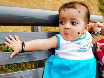 Cute baby girl on bench in park