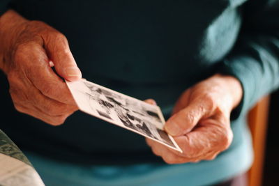 Midsection of man holding photograph