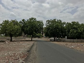 Road amidst trees against sky