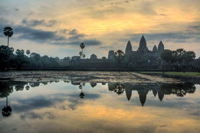 Reflection of angkor wat in lake at sunset