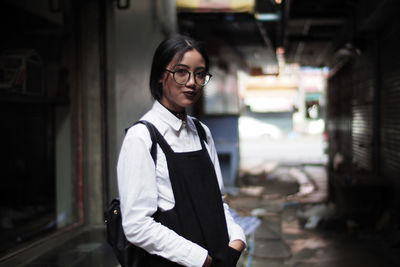 Portrait of smiling woman standing against buildings